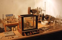 Assayer's office, with balance, crushers, and bone crucibles. To the left is the furnace for fire assaying.