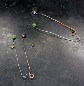 Borax glass beads. The green beads are on nichrome wire, the blue beads on copper wire.