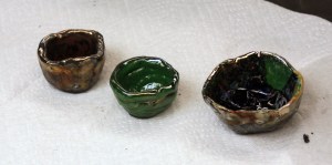 Some of the finished Raku pots. Mine is on the right. It's not as nice as others because I experimented with layering glaze colors.