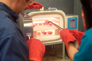 Removing the glowing red Raku pots from the kiln.
