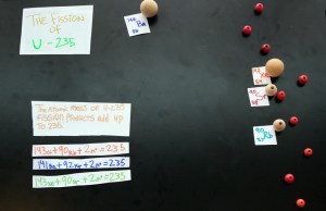 The nine neutrons travel on to split nine atoms of U-235 and release even more energy and more neutrons . . . thus becoming a chain reaction that will result in a nuclear explosion if left unchecked. Labels and equations can be added as the final particles migrate off the stage.