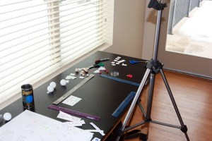Set up for the stop-motion animation activity. You will need a solid tripod, a black-topped table with good lighting, and rulers to mark the edges of the stage area (camera field of view).