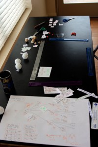 Animation stage (marked with rulers). Since the camera couldn't point straight down, the stage is a trapezoid. On the large sheet of paper is our storyboard/plan.